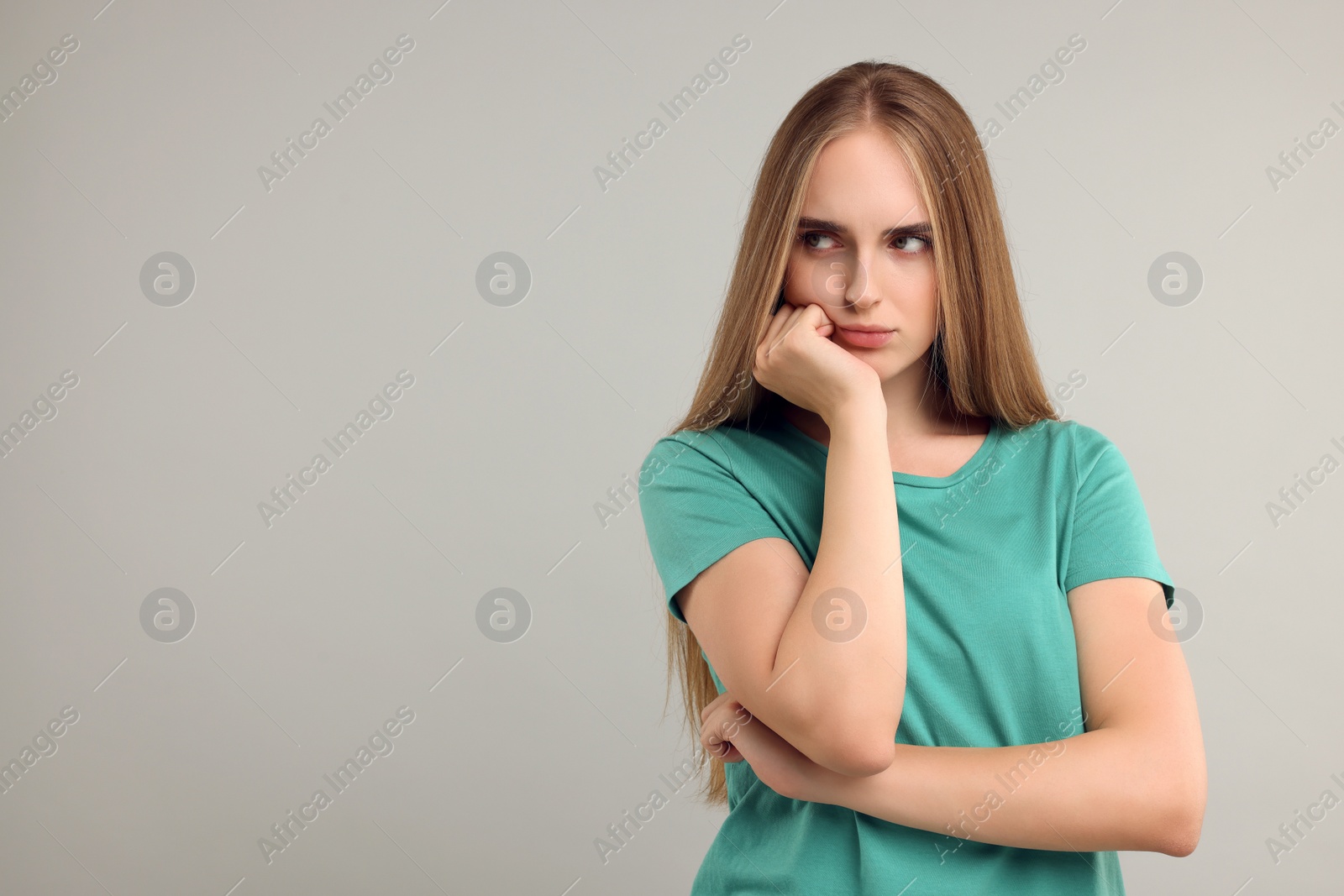 Photo of Resentful woman on grey background, space for text