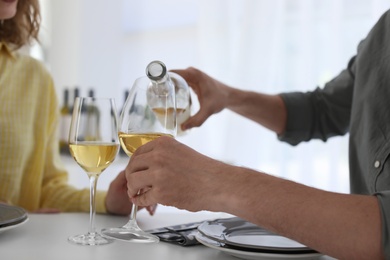 Photo of Young couple with glasses of wine at table in restaurant