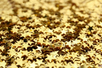 Photo of Shiny golden confetti stars, closeup. Christmas celebration