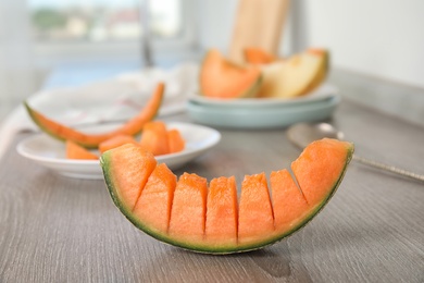 Photo of Slice of ripe cantaloupe melon on wooden table