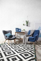 Photo of Modern interior with cozy armchairs and table near brick wall