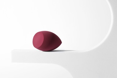 Photo of Stylish presentation of makeup sponge on white background