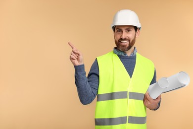 Photo of Architect in hard hat with drafts on beige background, space for text