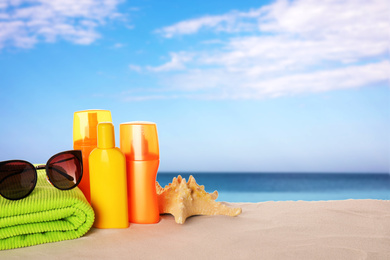Image of Set of sun protection products and stylish sunglasses on sandy beach. Space for text