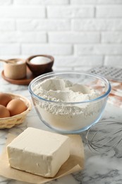 Photo of Making shortcrust pastry. Different ingredients for dough and whisk on white marble table