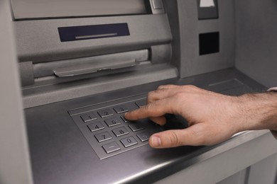 Photo of Man entering cash machine pin code, closeup