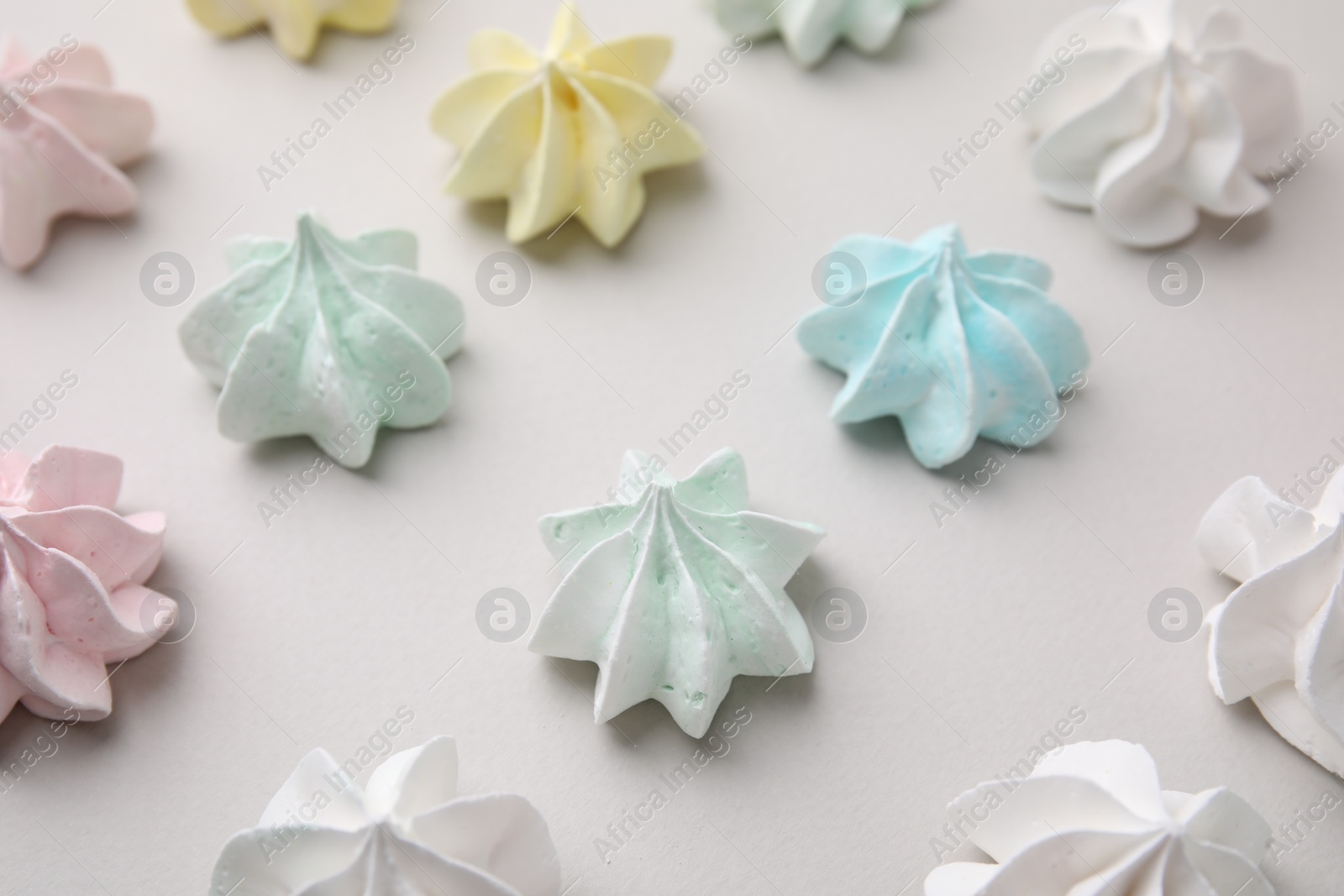 Photo of Delicious meringue cookies on light background, above view