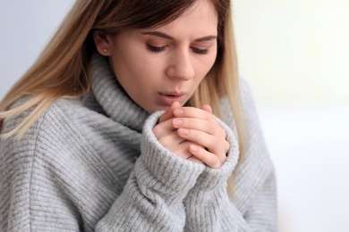 Photo of Sad woman suffering from cold on blurred background
