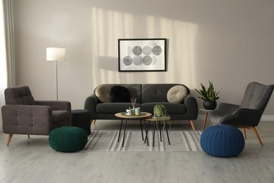 Photo of Stylish comfortable poufs and sofa in room. Home design