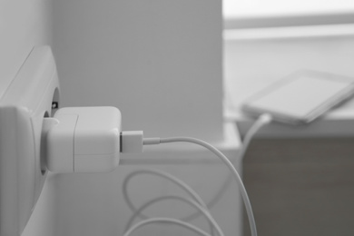 Photo of Modern smartphone charging from electric socket, closeup