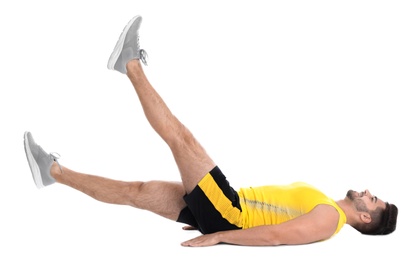 Photo of Handsome young man in sportswear doing scissors exercise on white background