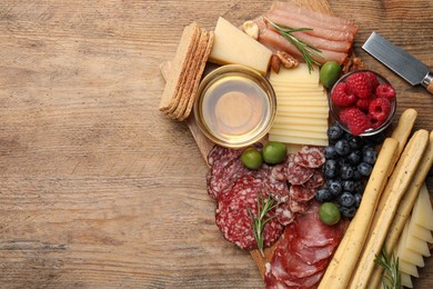 Snack set with delicious Parmesan cheese on wooden table, top view. Space for text