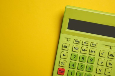 Photo of Green calculator on yellow background, top view with space for text
