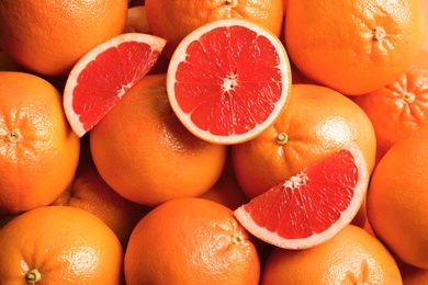 Many fresh ripe grapefruits as background, top view