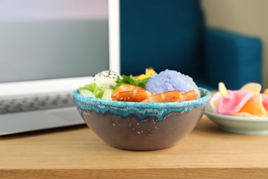 Photo of Delicious poke bowl served on wooden table