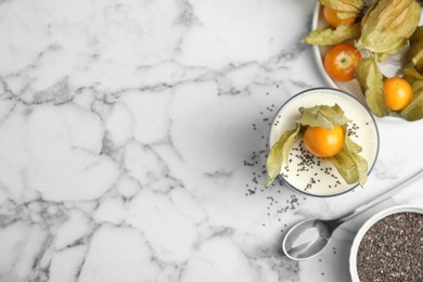 Photo of Delicious dessert decorated with physalis fruit on white marble table, flat lay. Space for text