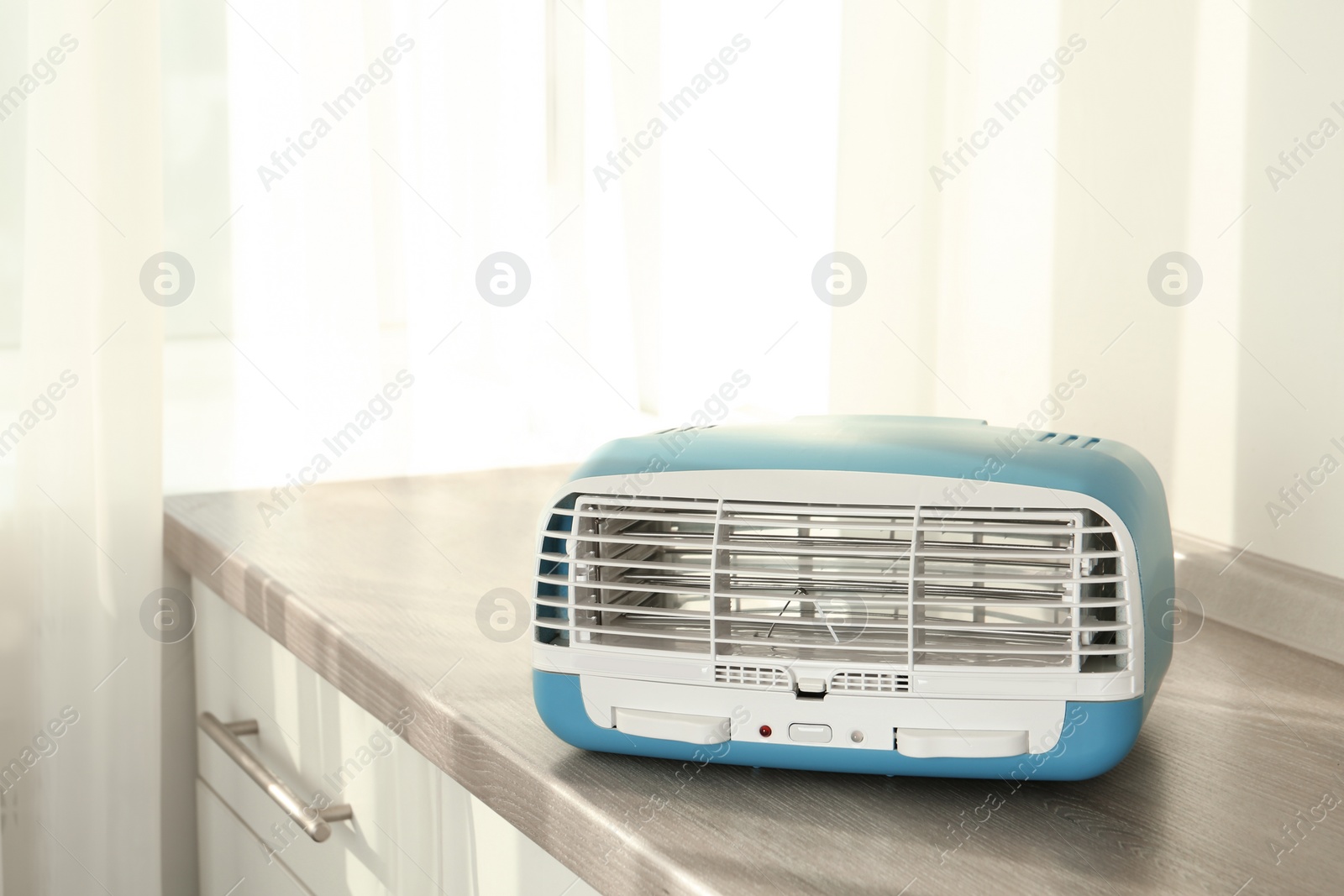 Photo of Stylish ionic air purifier indoors. Modern interior element