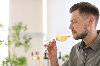 Young man with glass of wine indoors