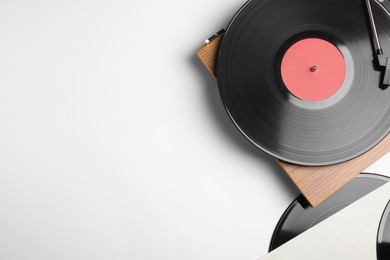 Photo of Modern vinyl record player with disc on white background, top view