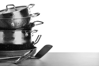 Photo of Set of clean cookware and utensils on table against white background, space for text