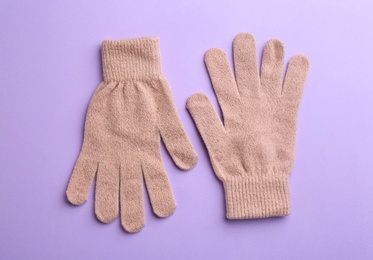 Photo of Pair of stylish woolen gloves on violet background, flat lay