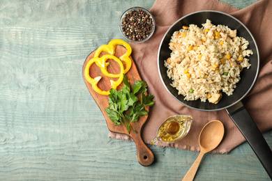 Photo of Delicious chicken risotto served on light blue wooden table, flat lay