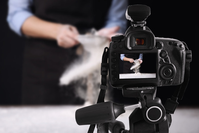Image of Food photography. Shooting of woman sifting flour, focus on camera