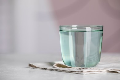 Photo of Glass of pure water on white table indoors, space for text