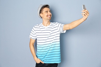 Photo of Young handsome man taking selfie against grey background