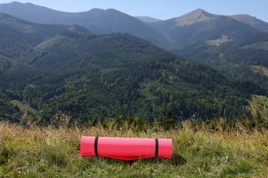 Photo of Rolled sleeping pad on grass in mountains