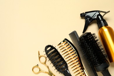 Photo of Hairdressing tools on beige background, flat lay. Space for text