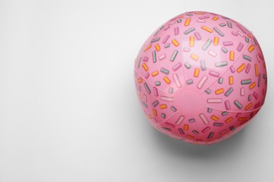 Photo of Pink beach ball on white background, top view. Space for text