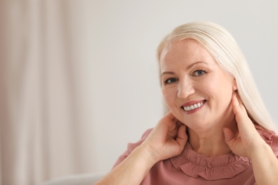 Photo of Portrait of beautiful older woman against blurred background with space for text