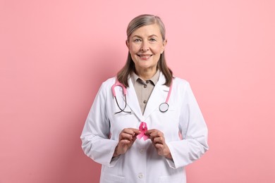 Photo of Mammologist with pink ribbon on color background. Breast cancer awareness