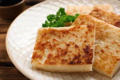 Photo of Delicious turnip cake with parsley on wooden table, closeup