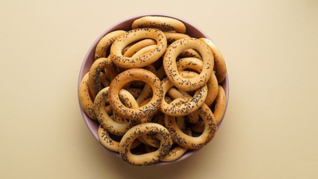 Photo of Bowl with delicious ring shaped Sushki (dry bagels) on beige background, top view