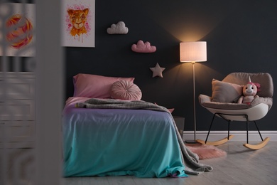 Photo of Bed with beautiful linens in children's room. Modern interior design