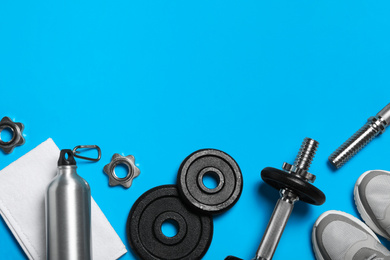 Photo of Gym equipment on light blue background, flat lay. Space for text