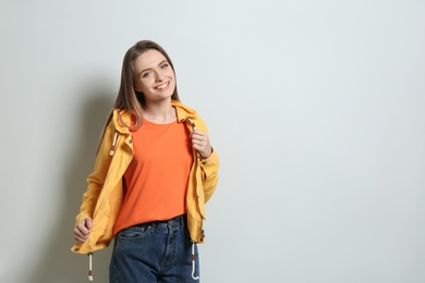 Photo of Young woman wearing blank t-shirt on light background. Mockup for design