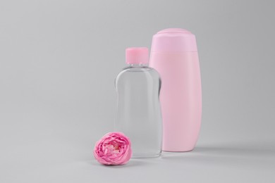 Photo of Different skin care products for baby and beautiful flower on light grey background. Space for text