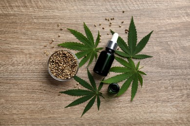 Photo of Flat lay composition with hemp leaves, CBD oil and THC tincture on wooden table