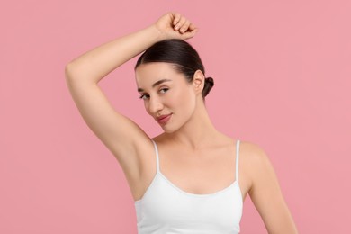 Photo of Beautiful woman showing armpit with smooth clean skin on pink background