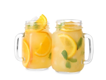 Mason jars with orange refreshing drink on white background