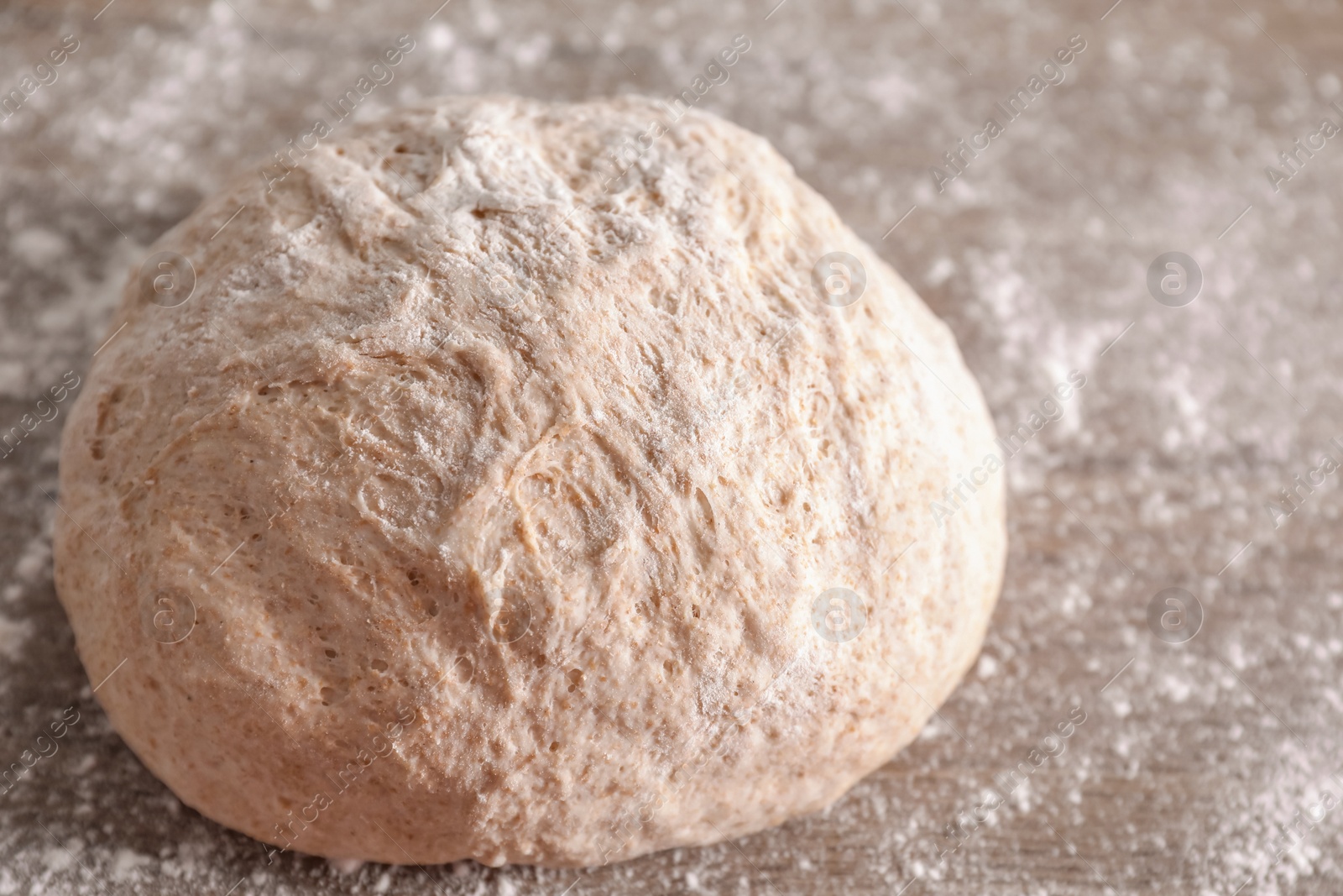 Photo of Fresh sourdough and flour on wooden table, closeup