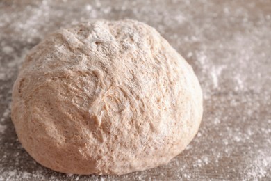 Fresh sourdough and flour on wooden table, closeup