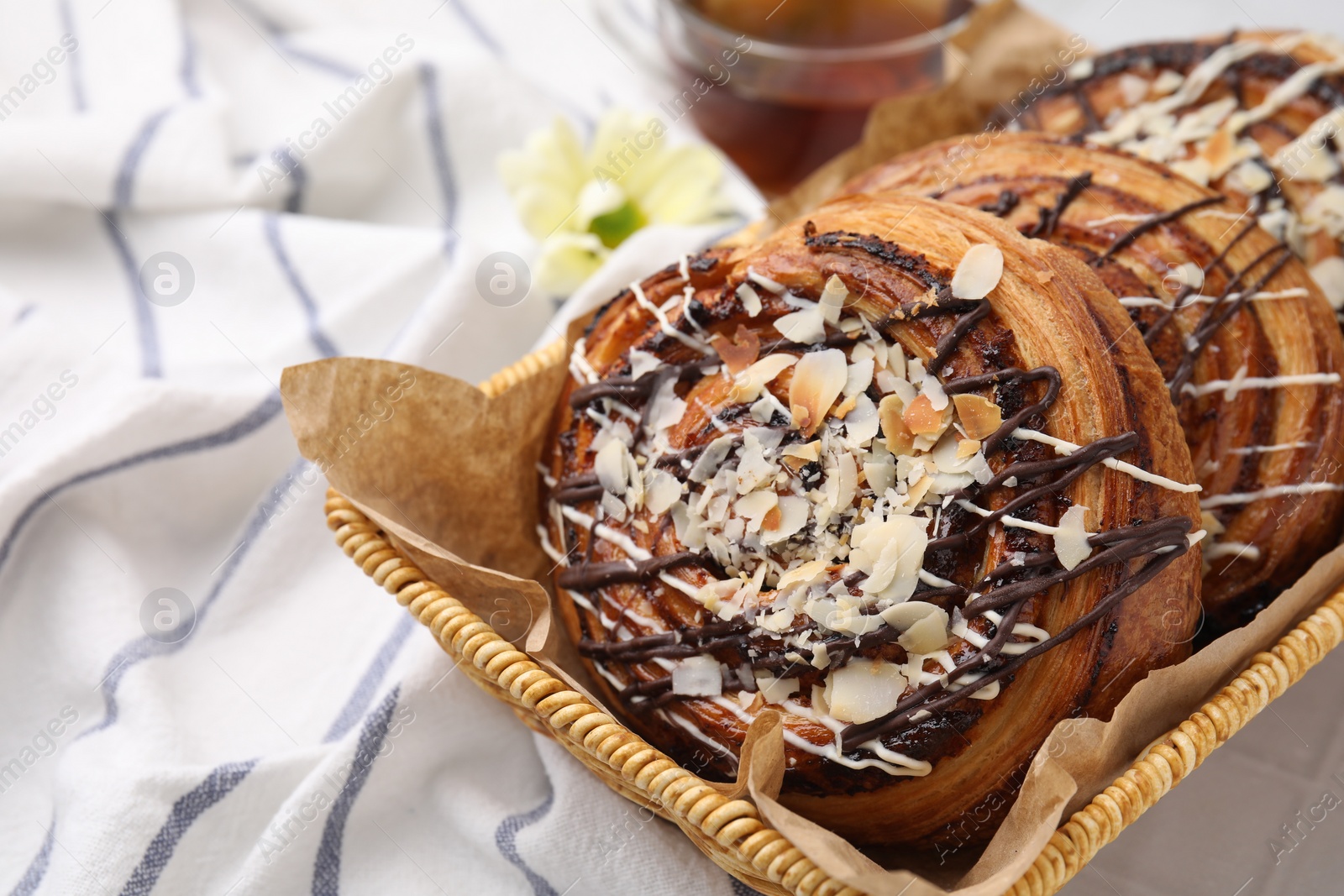 Photo of Sweet buns. Delicious rolls with toppings and almond on table, closeup. Space for text