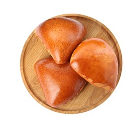 Wooden board with delicious baked patties on white background, top view