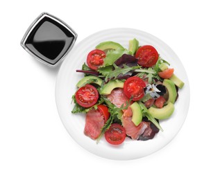 Photo of Tasty soy sauce and plate with salad isolated on white, top view