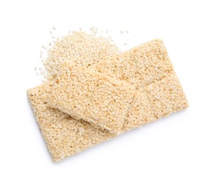 Photo of Delicious sweet kozinaki bars and sesame seeds on white background