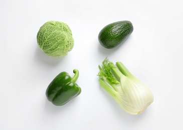 Green vegetables and fruit on white background, top view